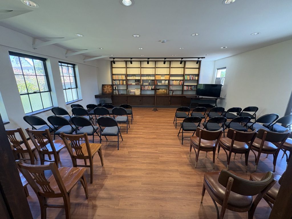 The Center's library set up for a lecture, with rows of chairs facing a lectern and a wall of bookshelves.